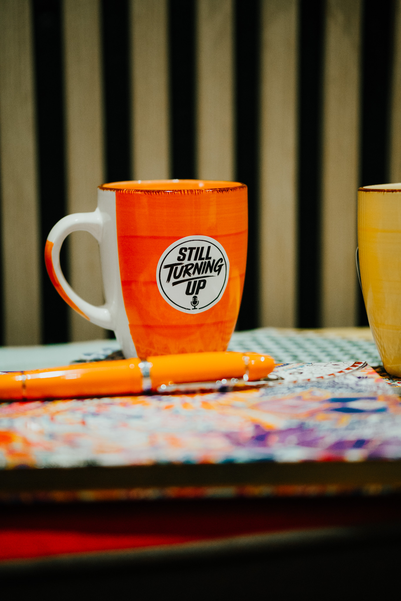 Still Turning Up mug and notebook on a warm table